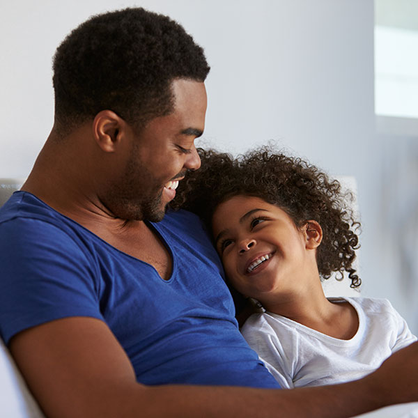 Father and Daughter Smiling on a Couch